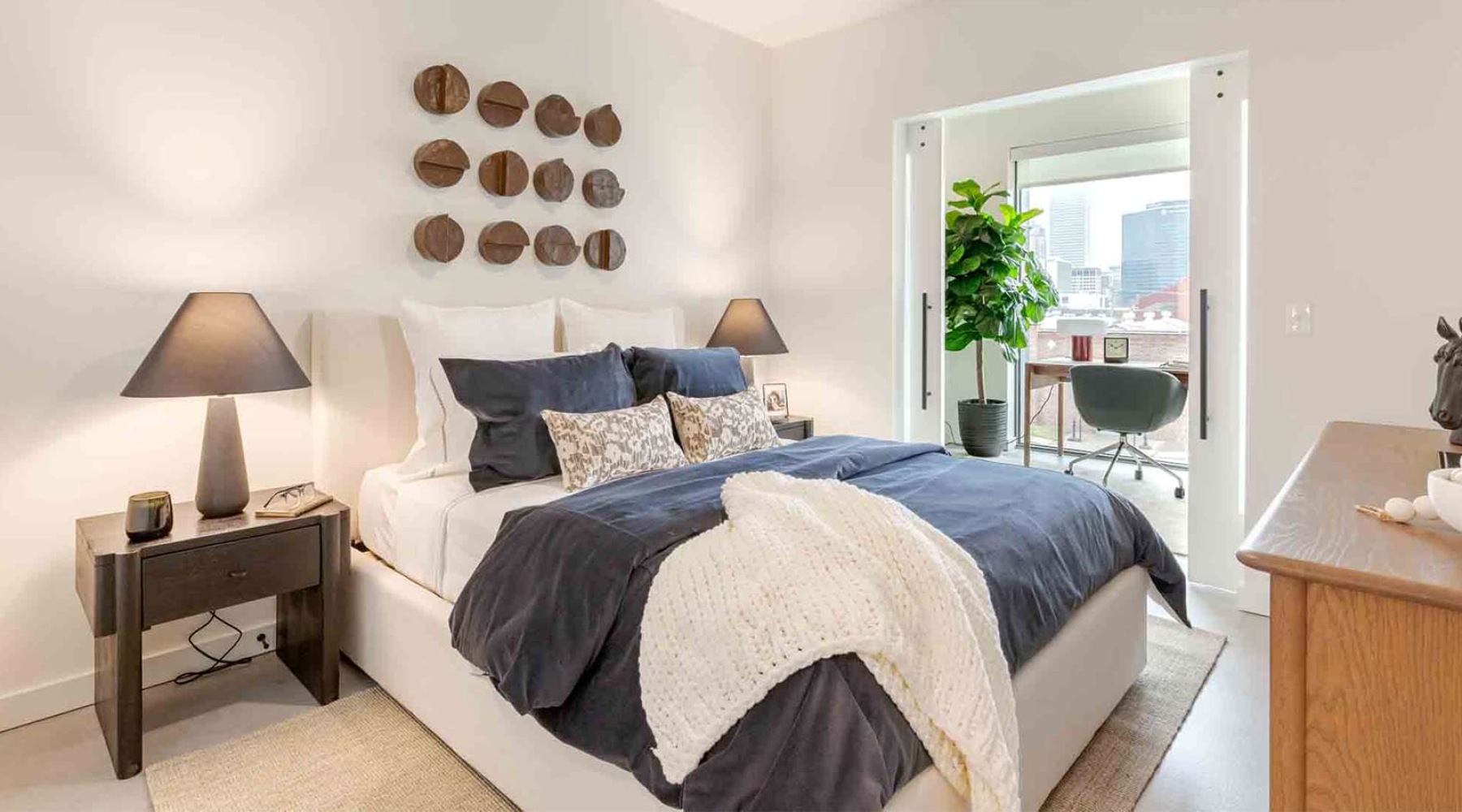 Bedroom with oversized windows and neutral finishes at Western Supply apartments for rent in Tulsa, OK.